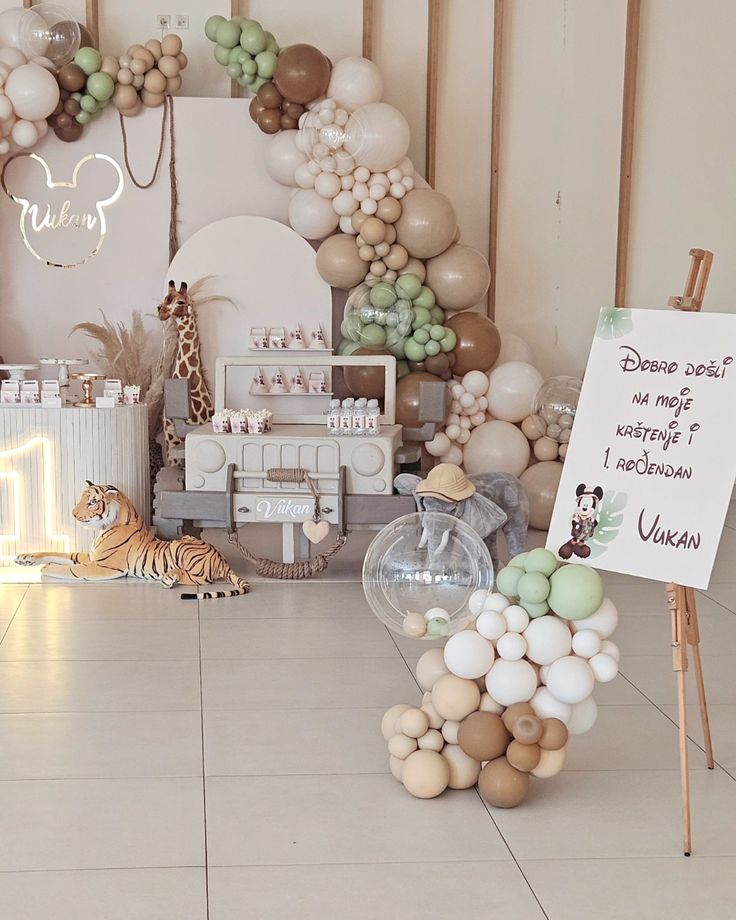 a room filled with balloons and decorations for a baby's first birthday party,