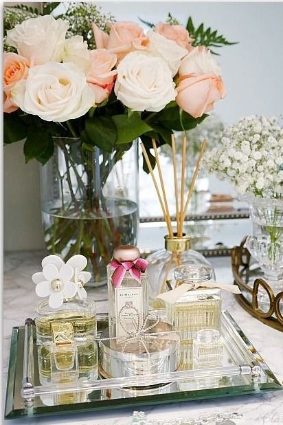 a table topped with vases filled with flowers and perfume bottles