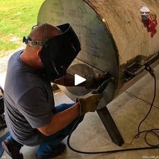 a man in a gas mask working on a tank