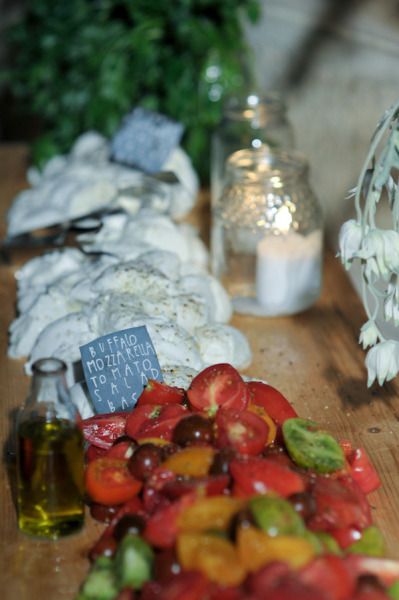 tomatoes, cucumbers and other vegetables on a cutting board with olives next to them