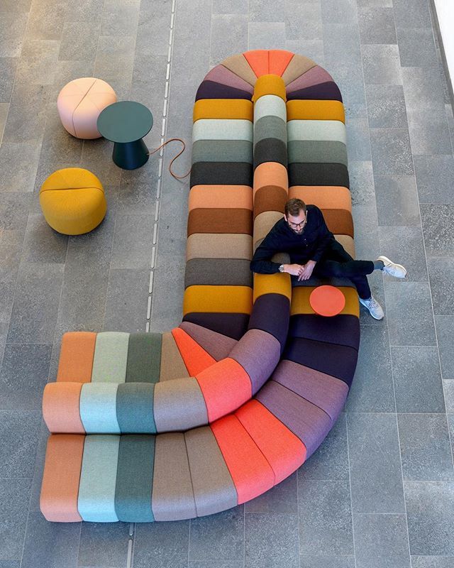 a person sitting on a multi colored couch