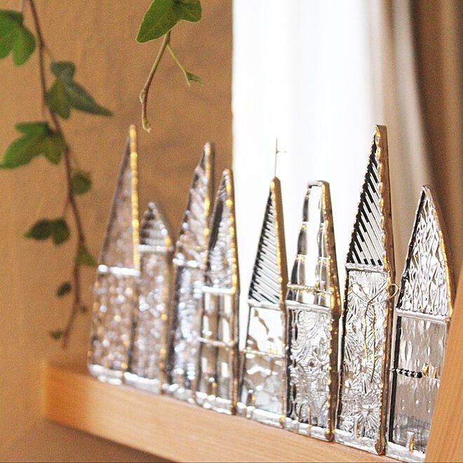 there are many small silver vases on the shelf next to each other and one is holding a green plant