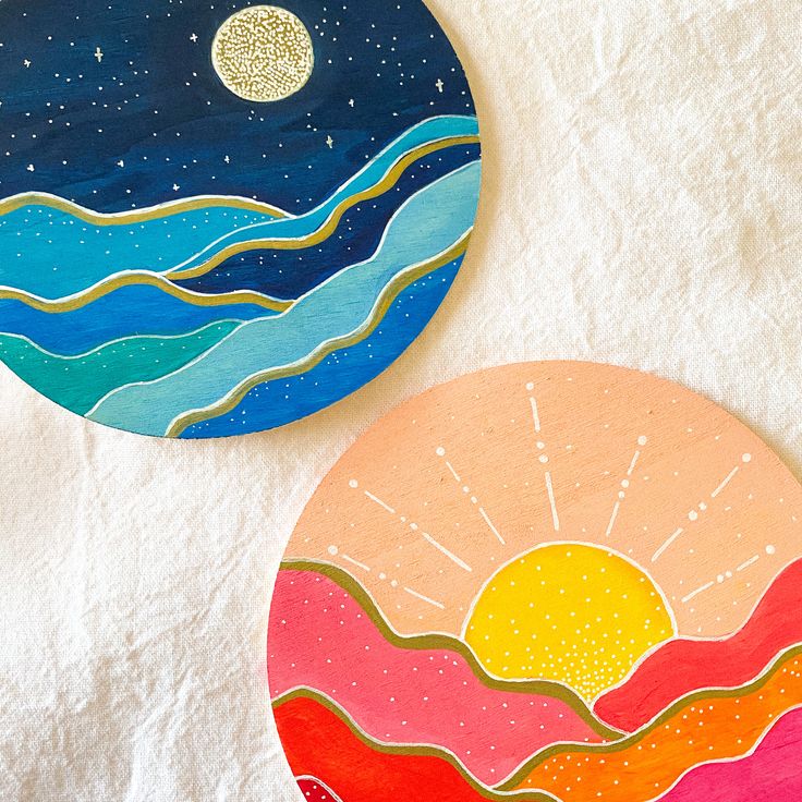 two painted plates sitting on top of a white towel