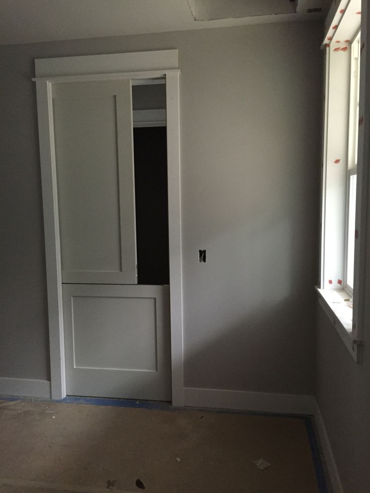 an empty room with white doors and no one in the house or someone is working on it