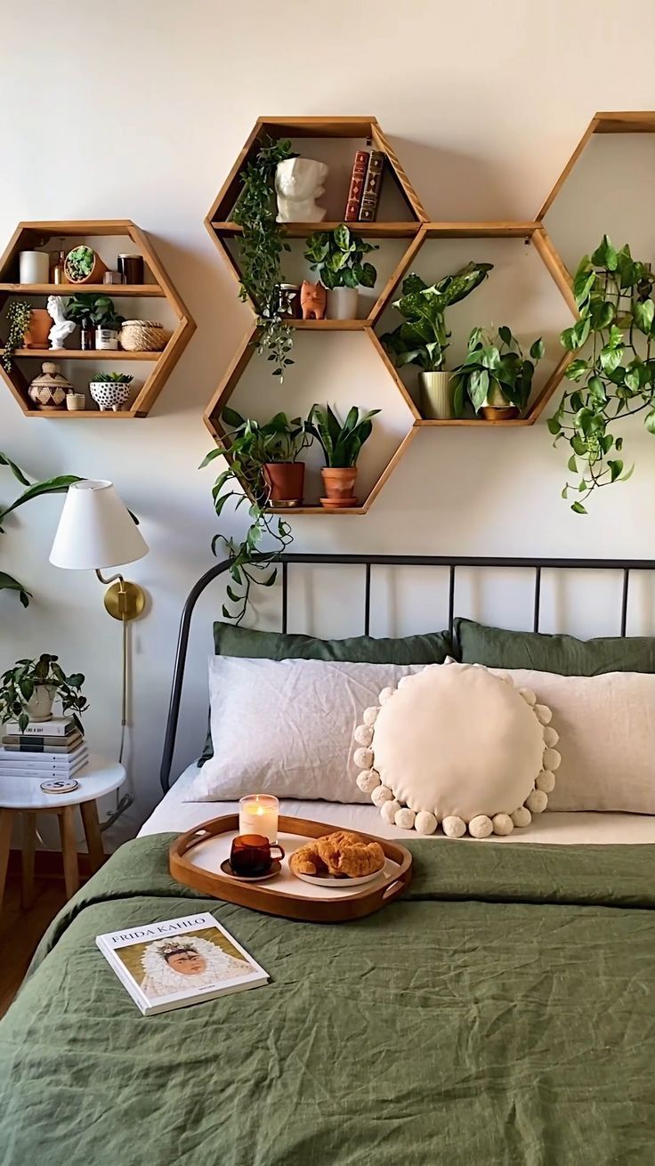 a bed topped with lots of plants next to a wall mounted shelf