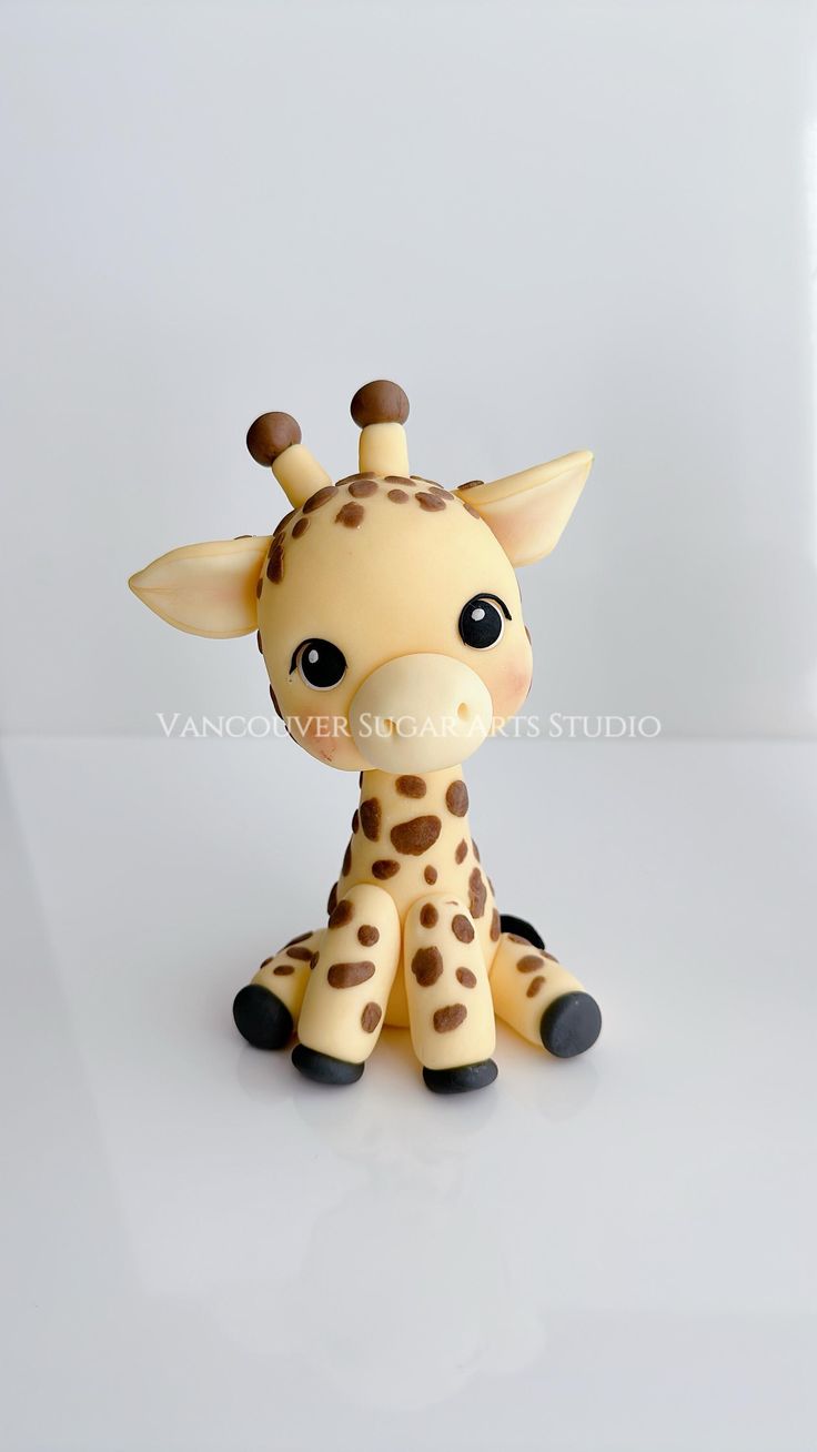 a toy giraffe sitting on top of a white table