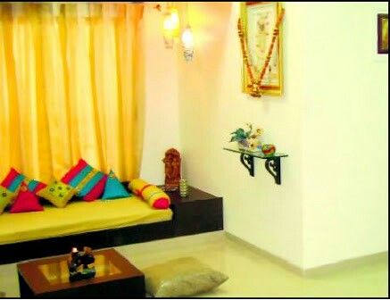 a living room with yellow drapes and colorful pillows on the couch, coffee table