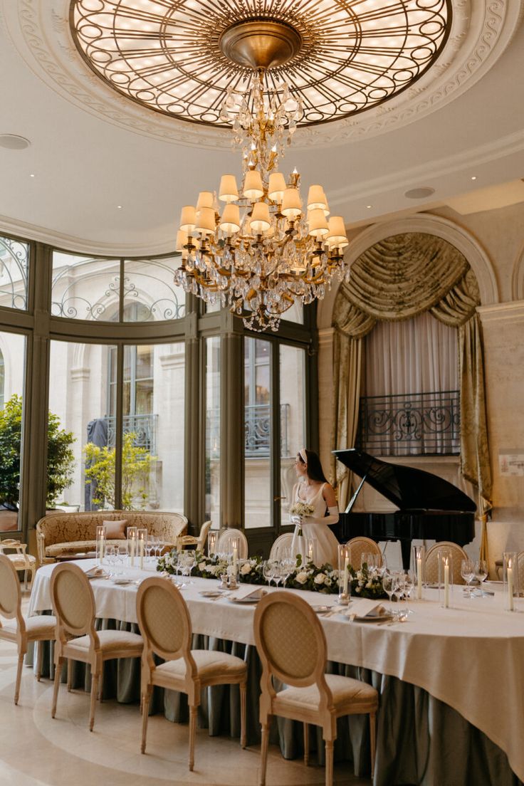 a woman sitting at a table in front of a piano