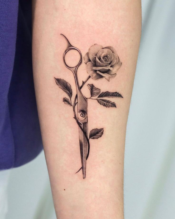 a rose and scissors tattoo on the arm