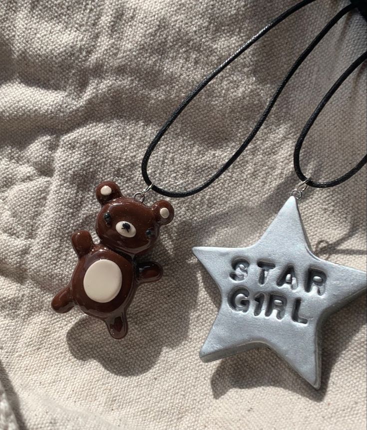 two necklaces that say star girl and a teddy bear