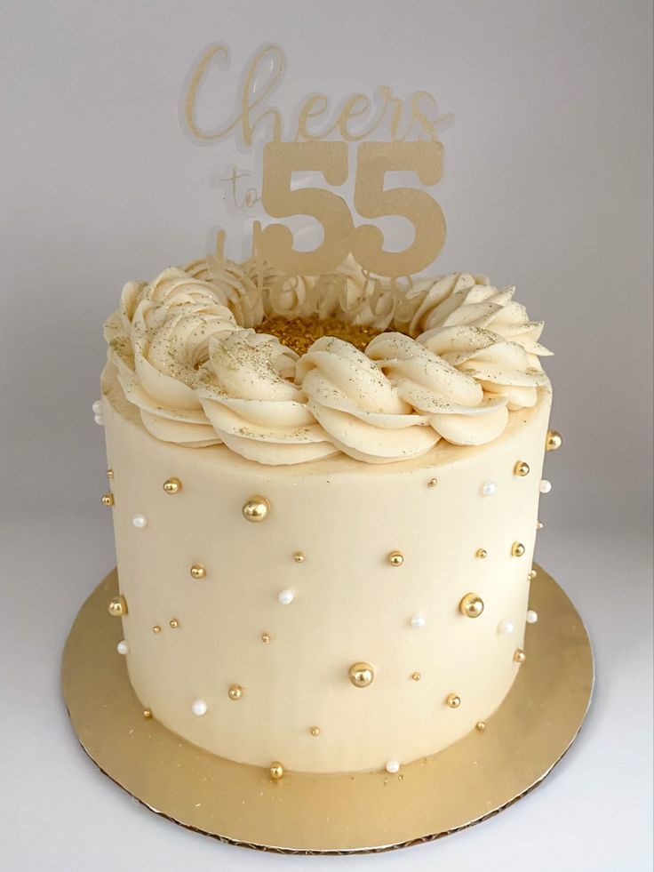 a cake with white frosting and gold decorations