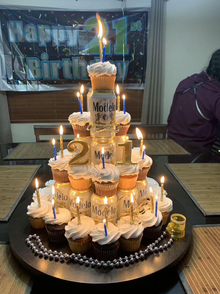 a birthday cake with cupcakes and lit candles