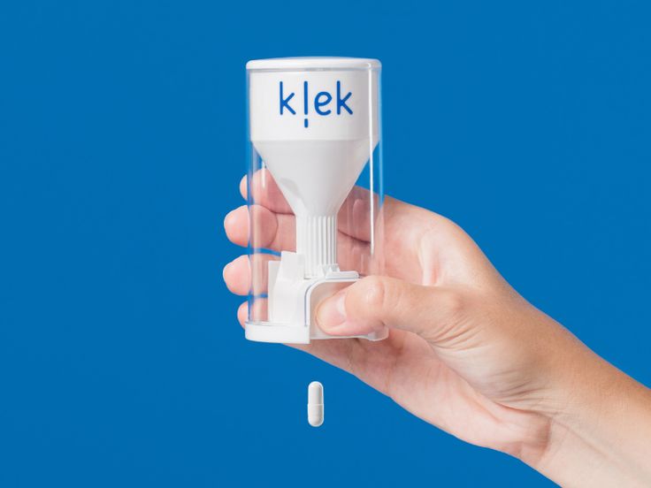 a hand holding a pill bottle with the word klek on it