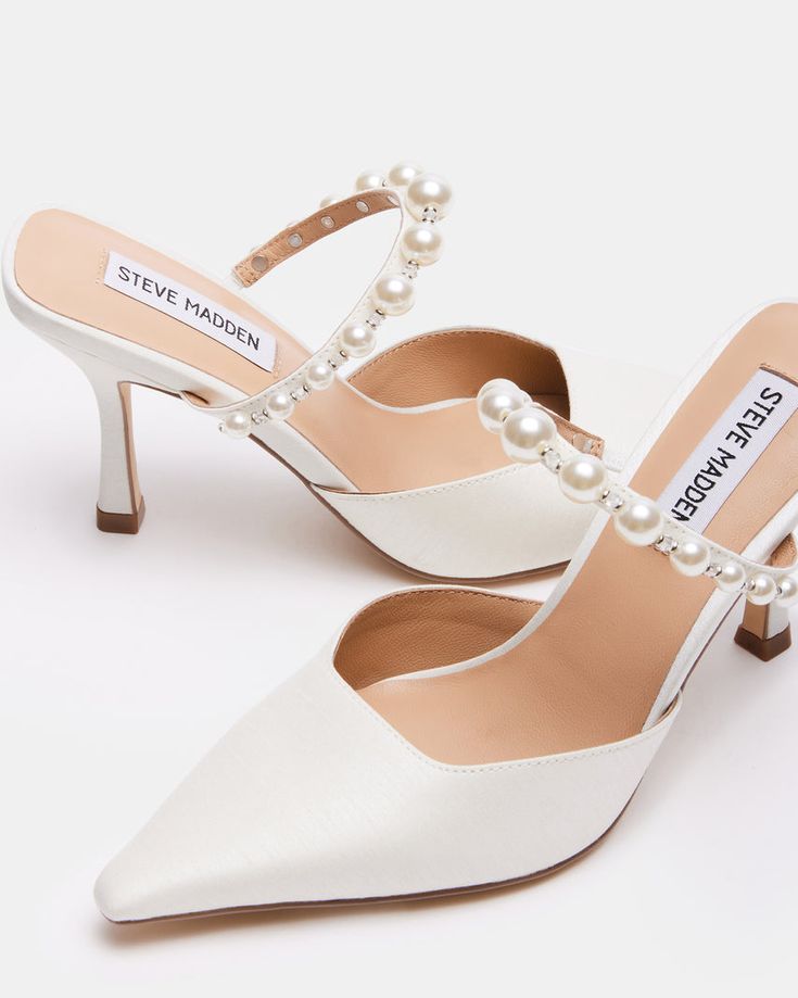 a pair of white shoes with pearls on the heel