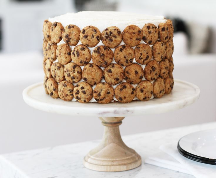 a cake with cookies and cream frosting sitting on top of a white tablecloth