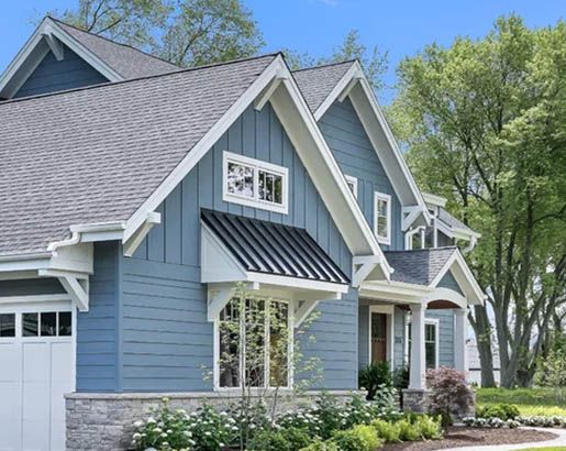 a blue house with white trim on the front and side windows is pictured in this image