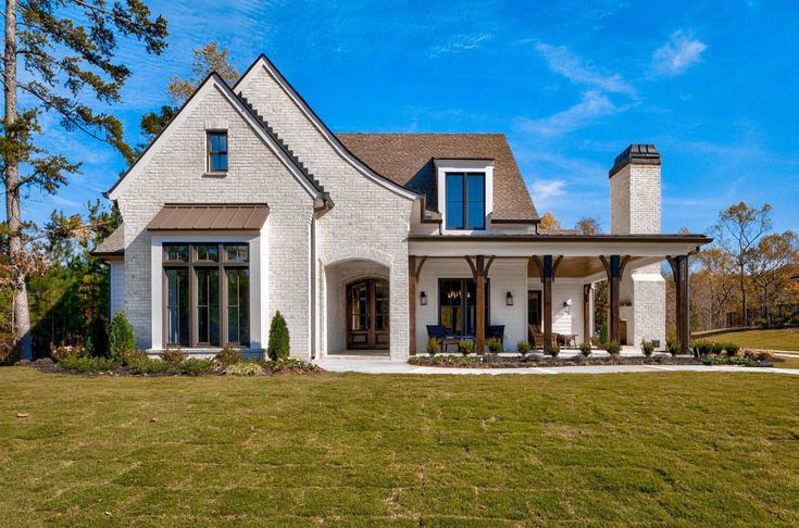 a white brick house with black shutters and windows