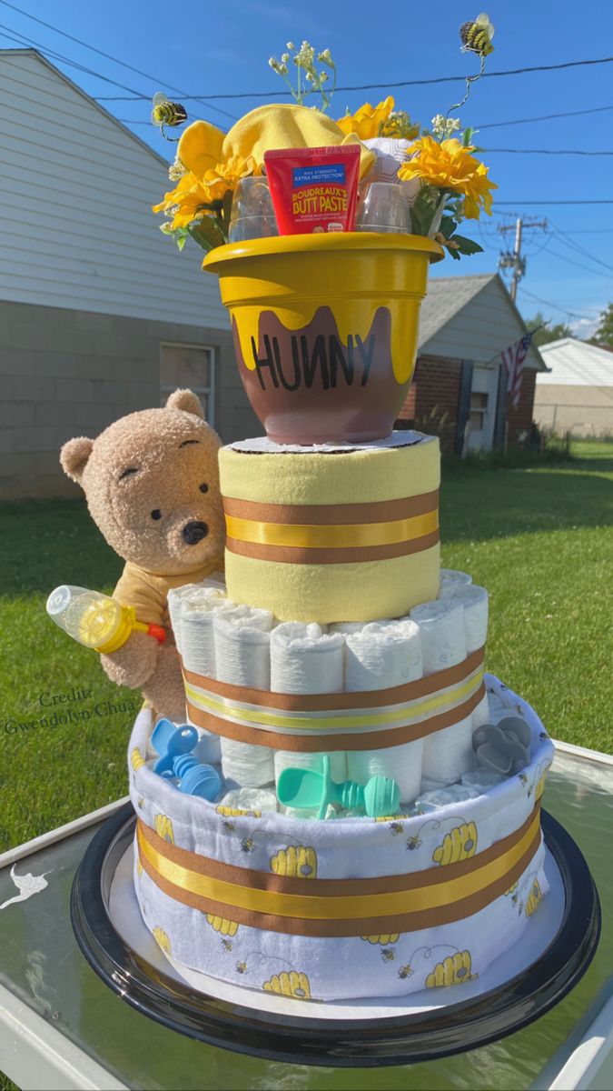 a teddy bear sitting on top of a diaper cake