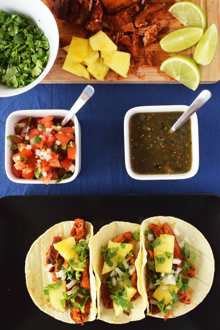 tacos al pastora with salsa and limes on the side