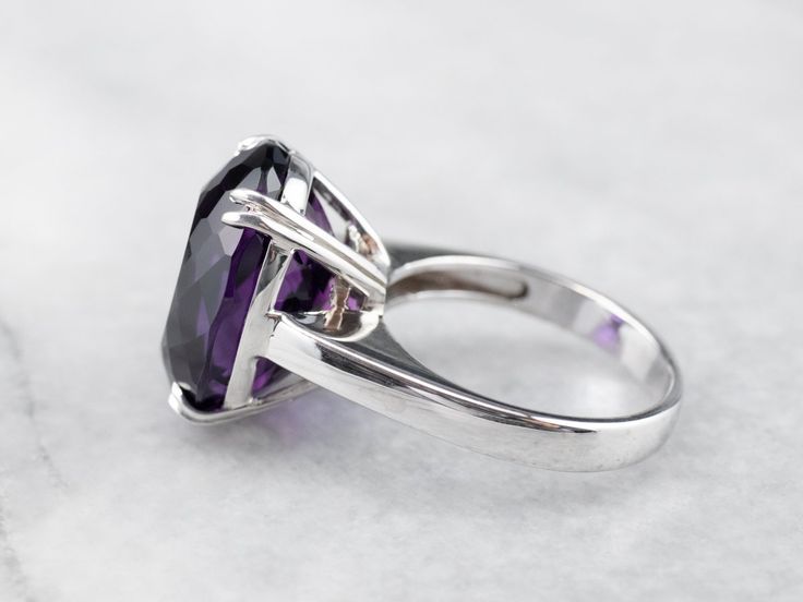 This exceptional amethyst commands attention! Generous in size, this gemstone sparkles with juicy hues of violet, fuchsia, and royal purple. A simple setting of 18 karat white gold lets the amethyst be the star of the show. Metal: 18K White Gold Gem: Amethyst 12.20 Carats Gem Measurements: 12.9 x 16.9 mm, Oval Ring Size: 6.25 Marks: "750" Stamped on the inside band Formal Amethyst Jewelry With Polished Finish, Elegant Purple Jewelry With Polished Finish, Formal Purple Amethyst Solitaire Ring, Formal Purple Solitaire Amethyst Ring, Formal Purple Diamond Cut Jewelry, Formal Purple Jewelry With Polished Finish, Elegant Purple Platinum Jewelry, Timeless Purple Jewelry For Formal Occasions, Classic Purple Amethyst Ring With Polished Finish