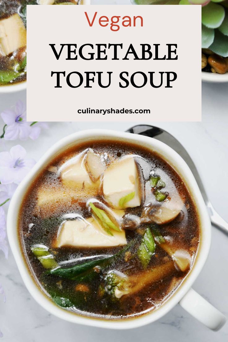 two bowls filled with vegetable tofu soup on top of a white table next to purple flowers