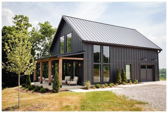 a modern house with large windows and a covered porch in the middle of a grassy area