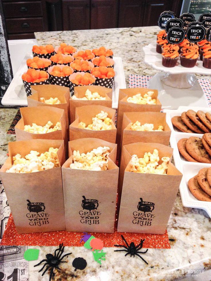 there are many bags full of snacks on the table with halloween decorations around them, including cookies and crackers