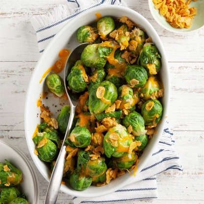 two white bowls filled with brussel sprouts on top of a table