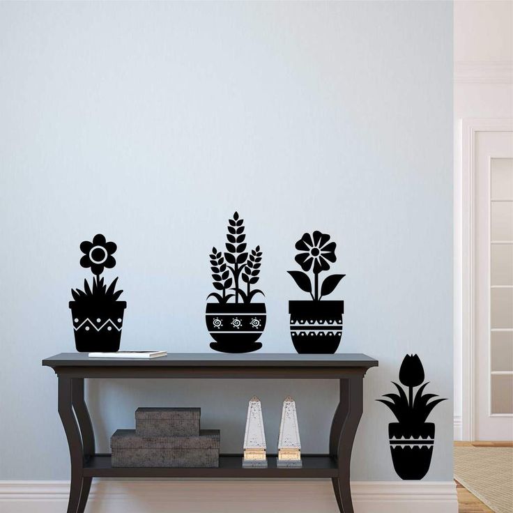 a table topped with potted plants next to a wall mounted on it's side