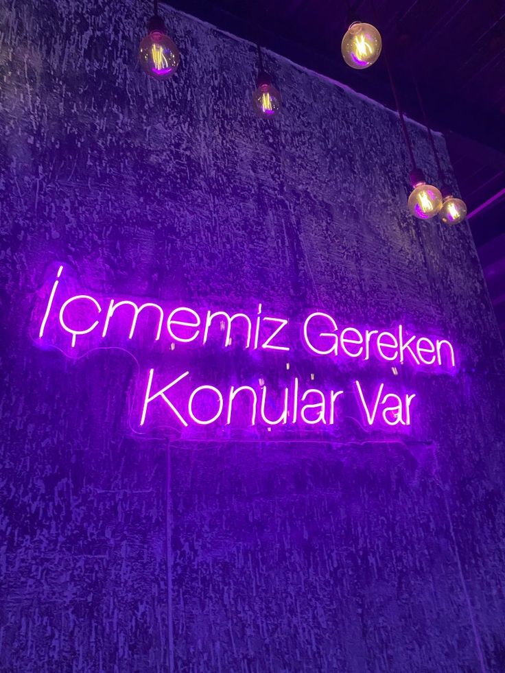 the neon sign for konjular var is lit up in front of a wall