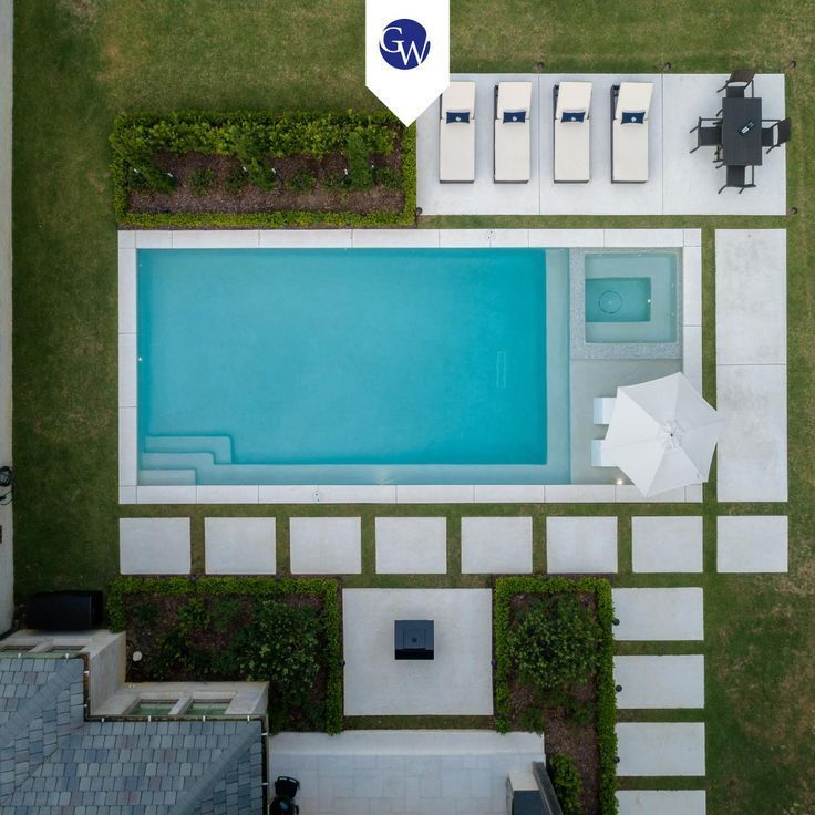 an aerial view of a swimming pool with lounge chairs