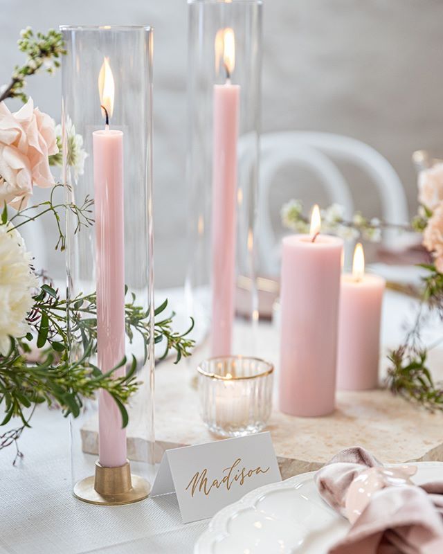 the table is set with pink candles and place cards for guests to write their names