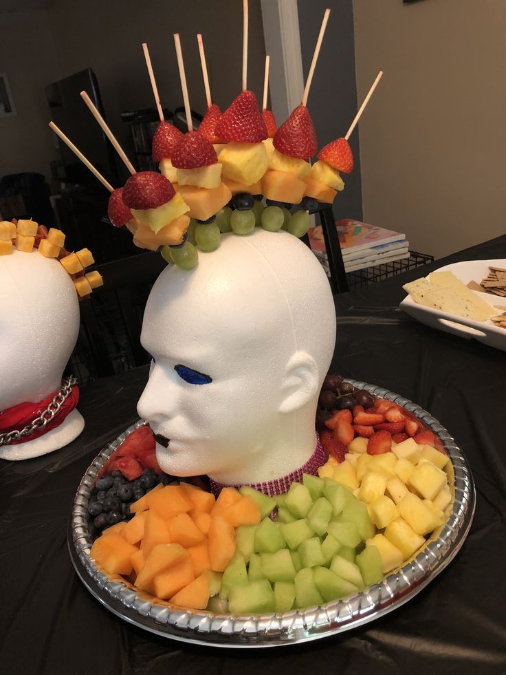 a plastic head with fruit on top of it