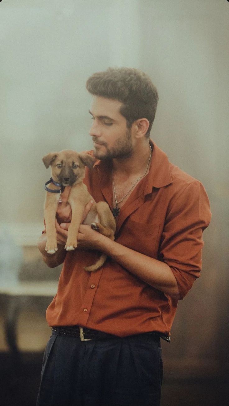 a man holding two puppies in his hands