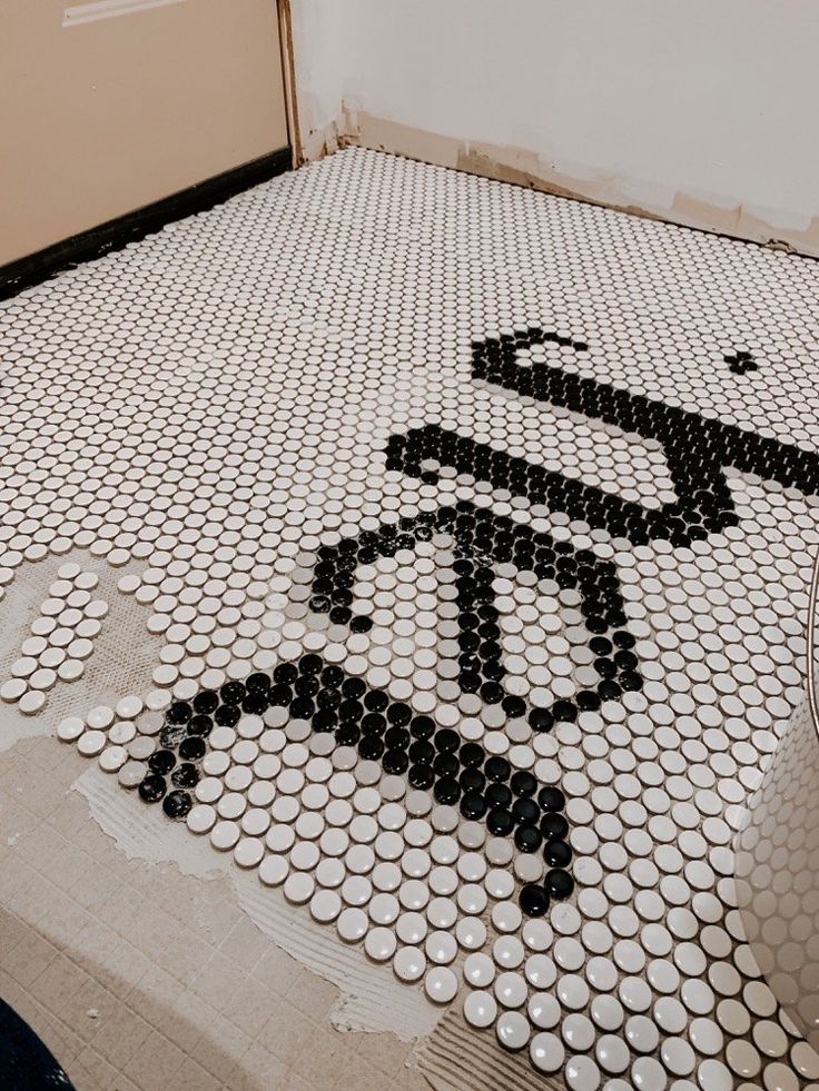 a bathroom floor that has been decorated with black and white circles in the shape of a bicycle