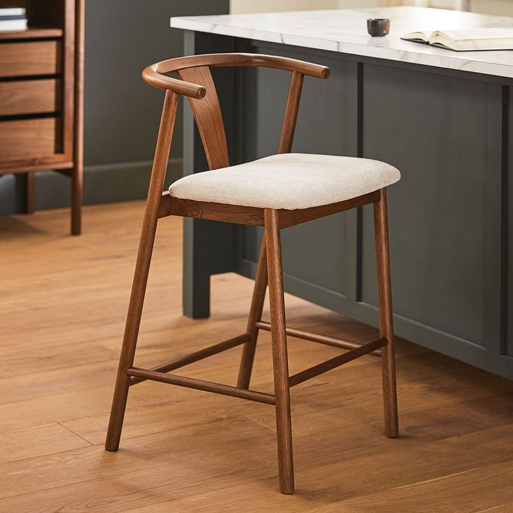 a wooden chair sitting on top of a hard wood floor next to a kitchen counter