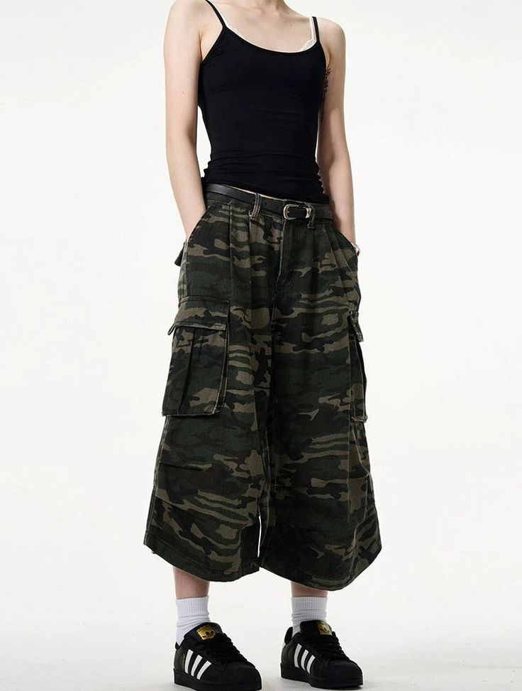 Embrace a fierce combination of style and practicality with our Camo Bermuda Capri Cargo Shorts. These high-waisted shorts feature a classic camouflage print, expertly crafted from a durable blend of materials for lasting comfort. The loose fit promotes freedom of movement while the integrated belt adds a functional, fashionable touch. Pair with a simple tee and sneakers for a laid-back look, or dress them up with a sleek blouse and ankle boots for a more sophisticated angle. Perfect for a varie High Waist Utility Shorts For Streetwear, High Waist Bottoms With Built-in Shorts For Streetwear, Combat Wide Leg Bottoms For Streetwear, Military Style Khaki Shorts, Sporty Camouflage Bottoms With Pockets, Summer Streetwear Cargo Pants With Belt Loops, Streetwear Hip-length Bottoms With Pockets, Khaki Military Style Shorts, Military Style Khaki Short Pants