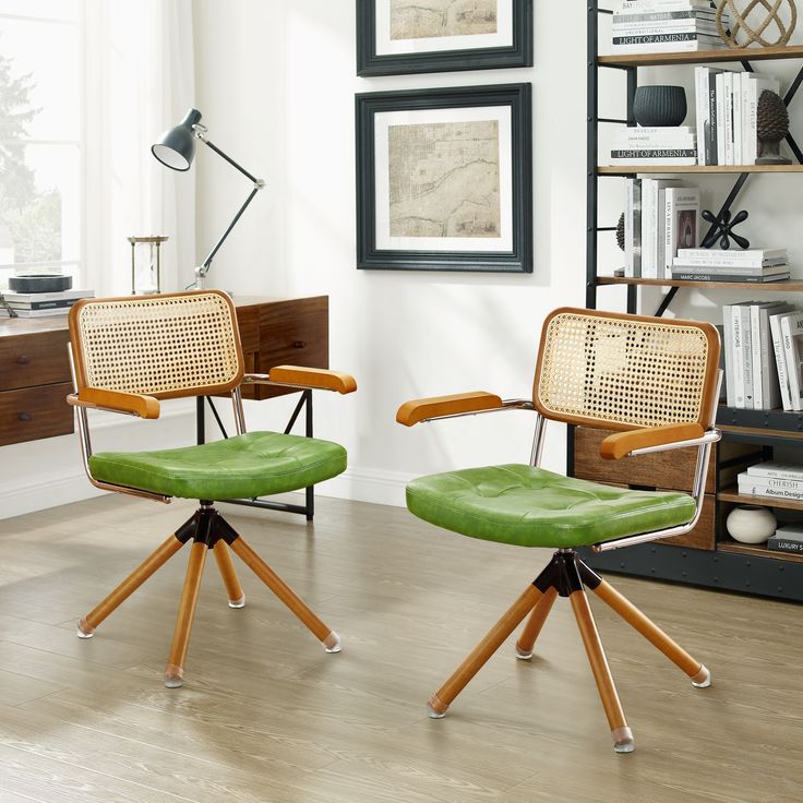 two office chairs with green upholstered cushions in front of a bookshelf