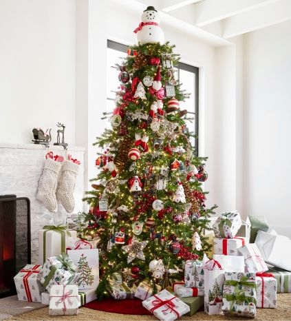 a decorated christmas tree in a living room with presents on the floor next to it