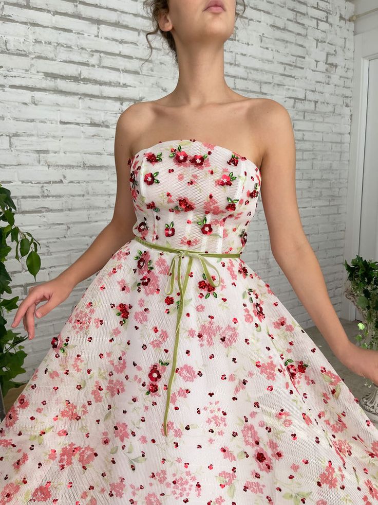 Enjoy long days and short nights in the Tulip Fields Gown. With a mesh-net fabric and a straight neckline, you can feel the warm summer wind on your skin. Embroidered with miniature flowers and crystal leaves so you can live in a blossoming garden... Feminine Spring Organza Gown, Spring Feminine Organza Gown, Sleeveless Organza Gown For Spring, Spring Gown With Floral Applique And Fitted Bodice, Spring Sleeveless Organza Gown, Summer Fitted Gown With Floral Applique, Fitted Floral Applique Summer Gown, Fitted Summer Gown With Floral Applique, Fitted Gown With Floral Embroidery For Garden Party