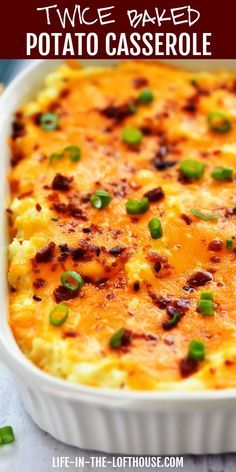 a casserole in a white dish topped with cheese and green onions, on a table