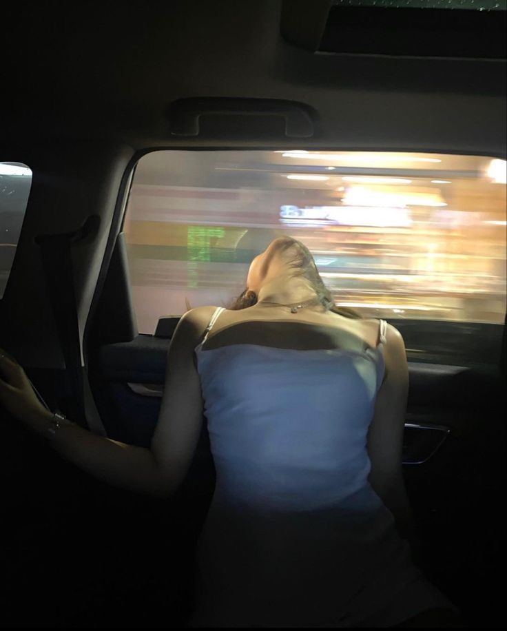 a woman sitting in the back seat of a car