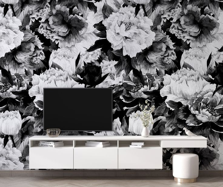 an entertainment center in front of a floral wallpaper with black and white flowers on it