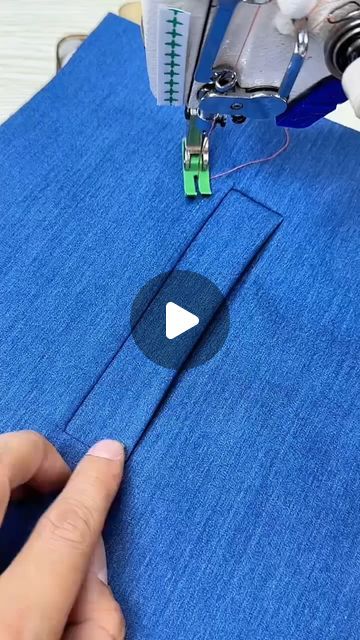 someone is sewing something on a blue piece of fabric