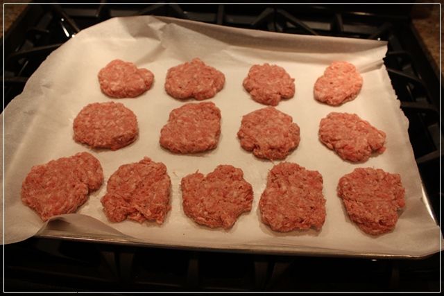 raw hamburger patties on a baking sheet ready to go into the oven in the oven