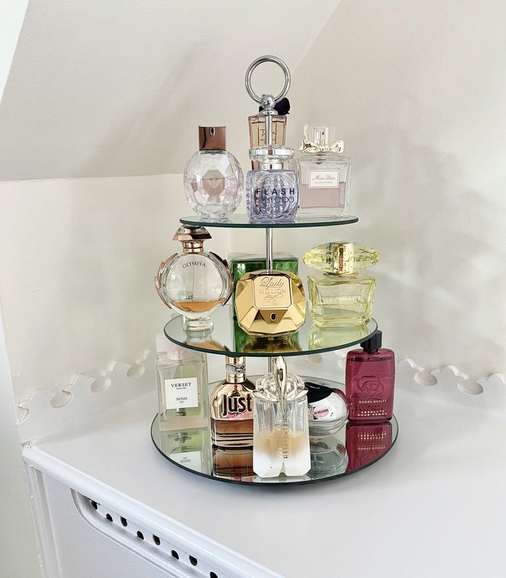 three tiered glass shelf with perfume bottles on it