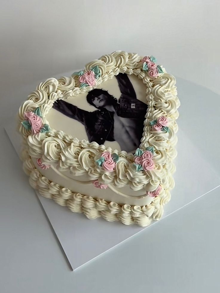 a heart shaped cake with an image of a man in the center on top of it