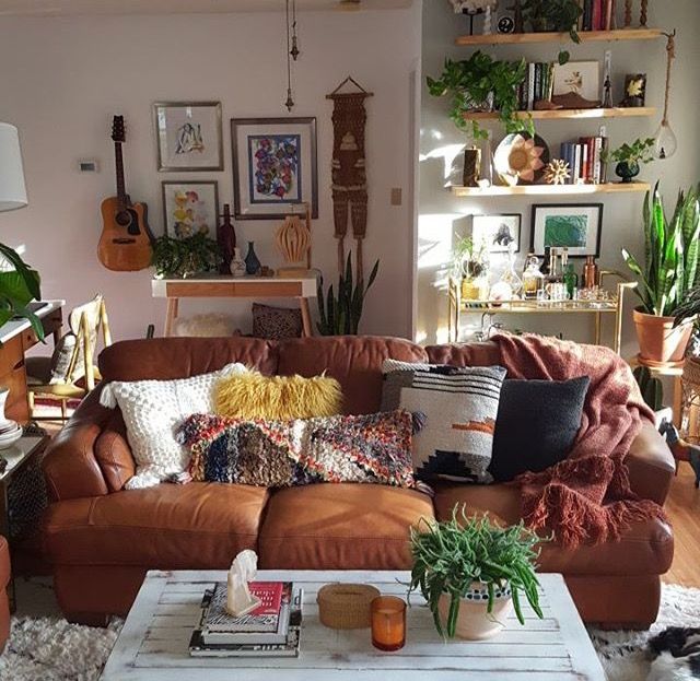 a living room filled with lots of furniture and plants on top of the couches