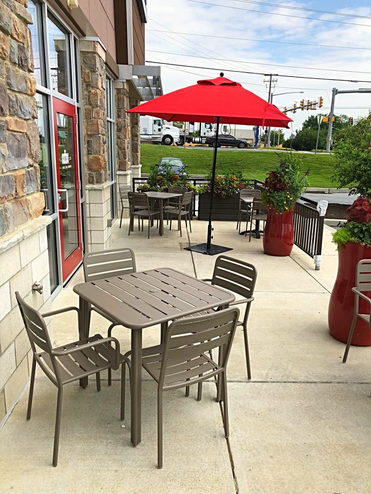 an outside patio with tables, chairs and umbrellas