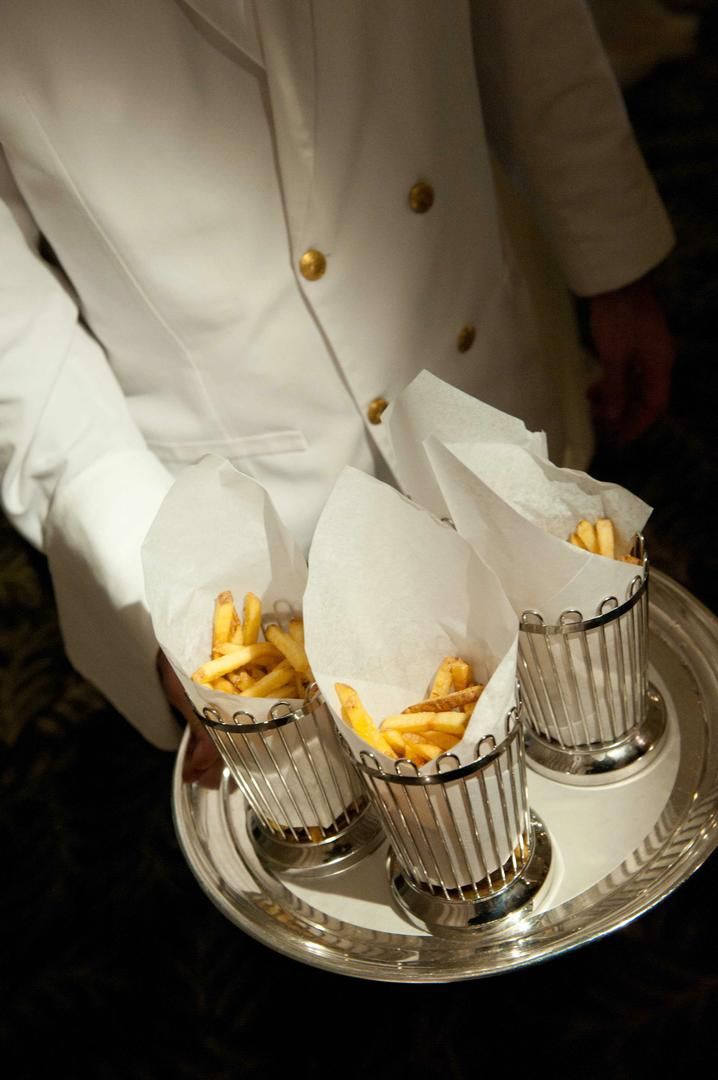 a tray with three cups filled with french fries on top of it and two napkins in the middle